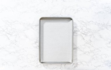 Flat lay. Dipping pretzels twists into melted chocolate to make red, white, and blue chocolate-covered pretzel twists.