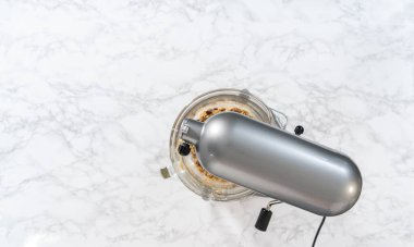 Düz yatıyordu. Yumuşak yulaflı kuru üzümlü cevizli kurabiyeler pişirmek için mutfak tezgahında karışımlar hazırlıyorum..