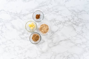 Flat lay. Measured ingredients in glass mixing bowls to bake banana oatmeal muffins.