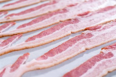 Pişmemiş pastırma şeritleri ve beyaz parşömen kağıtları..