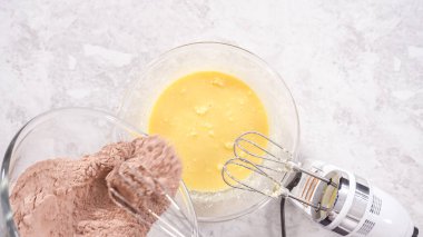 Düz yatıyordu. Adım adım. Kırmızı kadife kek hazırlamak için karıştırma kabındaki malzemeleri karıştırıyorum..