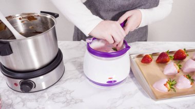 Adım adım. Erimiş çikolataya organik çilek batırmak..