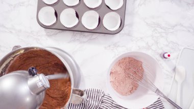 Düz yatıyordu. Adım adım. Kırmızı kadife kekler pişirmek için mutfak mikserinin malzemelerini karıştırıyorum..