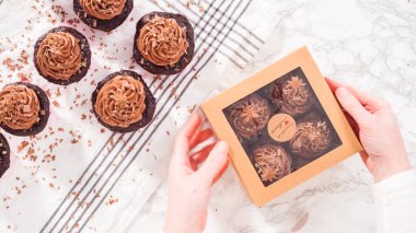 Düz yatıyordu. Adım adım. Çikolatalı kapkekleri çikolatalı ganache ile paketleyip kek kutusuna koymak..