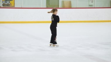 Küçük patenci sabah artistik patinaj antrenmanında elementlerini çalışıyor..