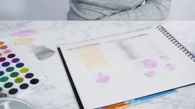 Zaman aşımı. Baker suluboyalı bir doğum günü pastası çiziyor..