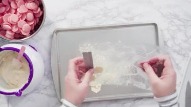 Time lapse. Flat lay. Step by step. Pouring melted chocolate into a plastic chocolate mold in the shape of snowflakes.