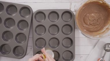 Düz yatıyordu. Çikolatalı ahududu kekleri pişirmek için folyolu kek bardaklarıyla kaplı kek tepsisi..