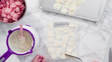 Düz yatıyordu. Adım adım. Erimiş çikolatayı kar taneleri şeklinde plastik bir çikolata kalıbına döküyorum..