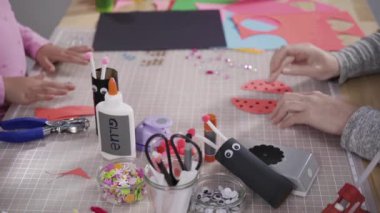 Close up view. Kids papercraft. Making paper bugs out of the empty toilet paper rolls and construction paper.