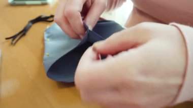 Koronavirüs salgını için dikiş makinesiyle pamuk yüz maskesi dikiyorum..