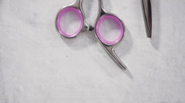 Gri arka planda pembe makasla yeni berber seti.