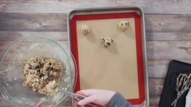 Time lapse. Flat lay. Step by step. Scooping cookie dough with a dough scoop into the baking sheet.