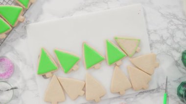 Düz yatıyordu. - Adım adım. Buzlu Noel ağacı şekilli şeker kurabiyeleri ve yeşil kraliyet kreması..