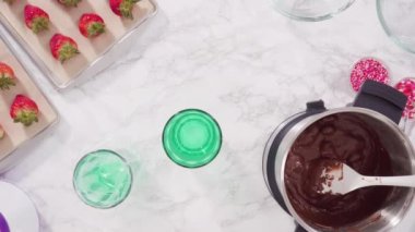 Düz yatıyordu. Adım adım. Çikolata parçacıkları eriyen kaplarda eriyor..