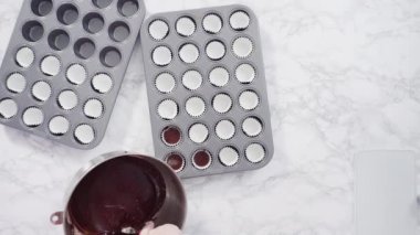 Düz yatıyordu. Adım adım. Mini çikolatalı kekler pişirmek için kek hamurunu mini kek kuyruklarına karıştırmak..