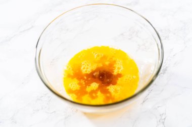 Mixing wet ingredients in a large glass mixing bowl to bake chocolate cookies with chocolate hearts for Valentines Day.