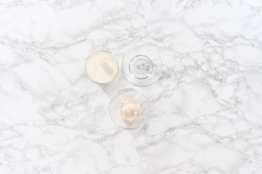 Düz yatıyordu. Mutfak masasında çörek pişirmek için gerekli malzemeler..