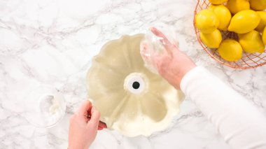 Düz yatıyordu. Adım adım. Bitkisel kısaltmalı ve beyaz un serpiştirilmiş yağlı kek tavası..