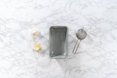 Flat lay. Greasing metal loaf baking pan to bake bread.