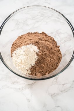 Büyük bir bardaktaki malzemeleri karıştırarak naneli çikolatalı kekler pişiriyorum..