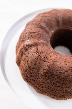 Beyaz pasta standında taze pişmiş çikolatalı kek..