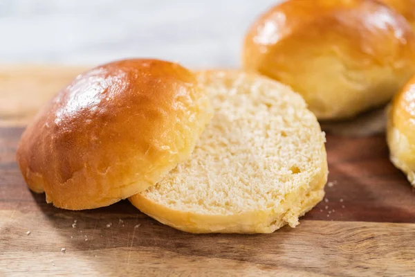 Odun kesme tahtasının üzerinde taze pişmiş çörekleri dilimliyorum..