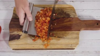 Ağaç kesme tahtasındaki organik kırmızı dolma biberler..