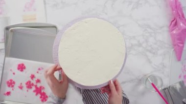 Düz yatıyordu. Adım adım. Yuvarlak funfetti pastasını pembe ve beyaz fondant kar taneleriyle süslüyorum..