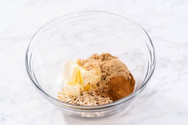 Tarçın kırıntılarını hazırlamak için büyük bir bardakta karışımı karıştırıyorum..