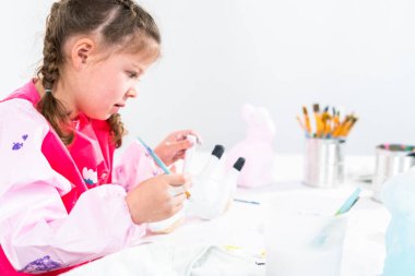 Küçük kız COVID-19 salgınında evde uzaktan öğrenim için sanat projesi üzerinde çalışıyor..