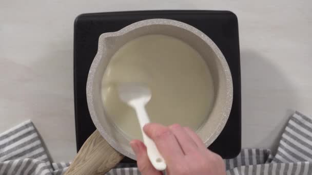 一步一步 平躺在床上在电锅上的小平底锅里准备巧克力糖霜 — 图库视频影像