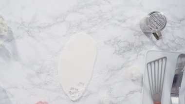 Düz yatıyordu. Adım adım. Beyaz fondantımızı mermer tezgahta yuvarlıyoruz..