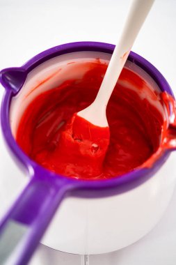 Çikolata parçalarını eritip, eritip, sevgililer günü için çikolata kaplı çubuk çubuk kraker yapmak..