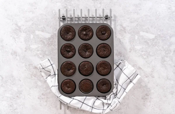 Flat lay. Cooling freshly baked chocolate cupcakes on the counter.