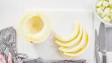 Adım adım. Düz yatıyordu. Beyaz kesme tahtasında kaygan altın çiğ taneli kavun.