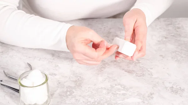 Woman finishing her manicure at home with simple manicure tools. Buffering nails with a nail buffer block.