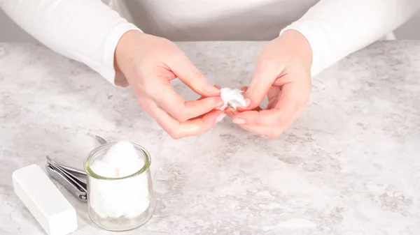 Woman finishing her manicure at home with simple manicure tools. Removing old nail polish from the nails.