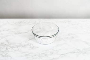 Küçük Paskalya ekmeği için limon jölesi yapmak için karışımı büyük bir karıştırıcı ile karıştırıyorum..