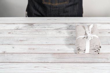 Beyaz ahşap bir masada yeni bir peçete yığını..