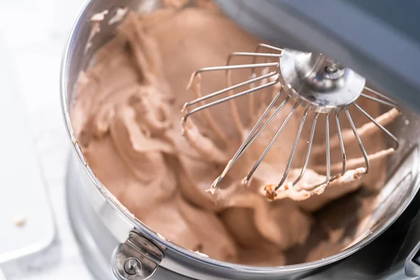 Mixing ingredients in a standing kitchen mixer to make homemade chocolate ice cream.