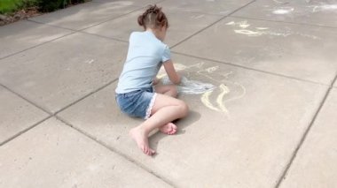 Bir yaz günü banliyö yolunda tebeşir çizen küçük bir kız..