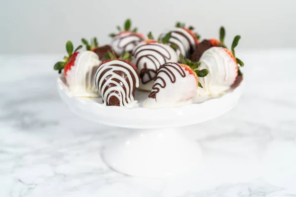 Weiße Und Dunkle Schokolade Eingetauchte Erdbeeren Auf Einem Weißen Kuchenstand — Stockfoto