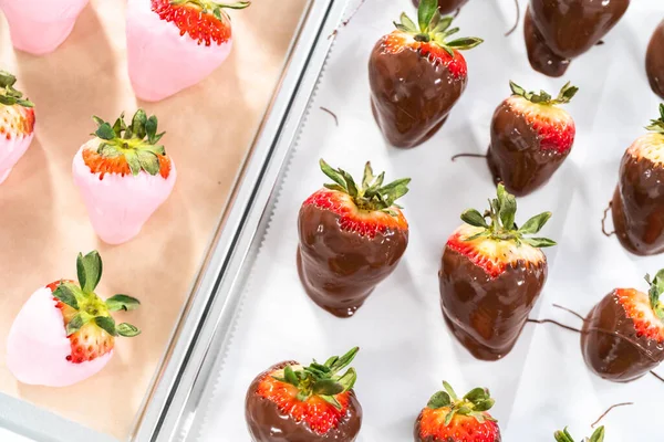 Close up of chocolate dipped strawberries on a parchment paper.