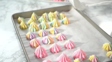 Adım adım. Taze pişmiş tek boynuzlu at meringue kurabiyeleri ve bir parşömen kâğıdı..