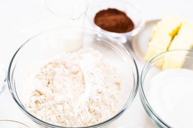 Çikolatalı kek pişirmek için cam kaselerdeki malzemeler..