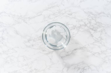 Soğuk su ve buz dolu cam bir kasede haşlanmış yumurta soğutmak..