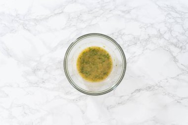 Düz yatıyordu. Sarımsaklı ıstakoz kuyruğu için tereyağı karışımı hazırlamak için bardaktaki malzemeleri karıştırıyorum..