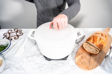 Dökme demir Hollanda fırınında vejetaryen beyaz fasulye çorbası pişirmek.