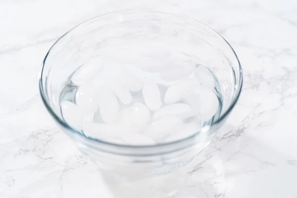 用冷水和冰块把煮熟的鸡蛋放在玻璃碗里冷却 — 图库照片